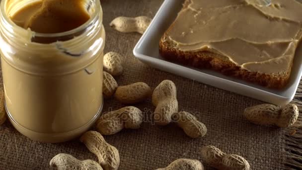 Смачне арахісове масло розкладається на білому тості — стокове відео