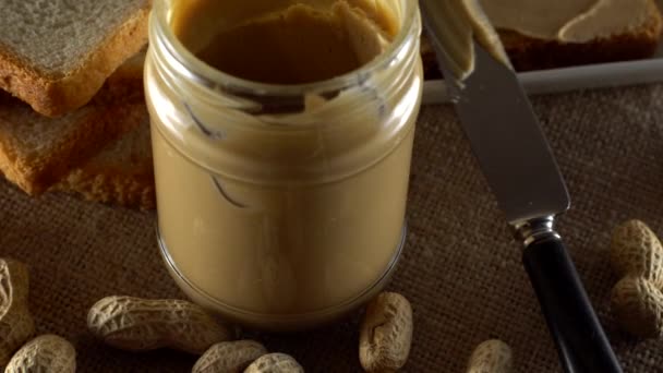 Tasty peanut butter being spread on white toast — Stock Video