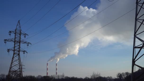 Stromleitungen und Rohrrauchkraftwerk gegen blauen Himmel. — Stockvideo