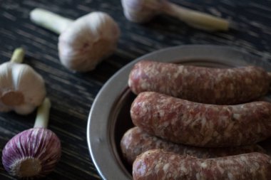 Ahşap yüzey üzerinde sarımsaklı çiğ sosis