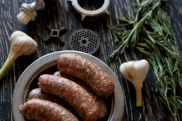 Ruwe worstjes, knoflook, rozemarijn en oude vlees slijper onderdelen — Stockfoto