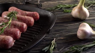 Çiğ sosis ile sarımsak, biberiye ahşap yüzey üzerinde