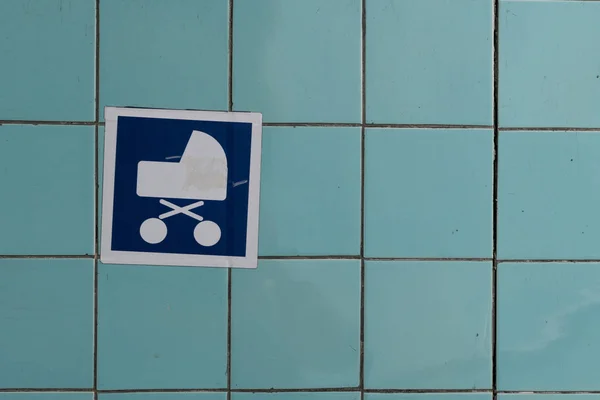 Bambino segno passeggino, appeso su una parete blu . — Foto Stock