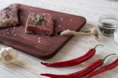 Biberiye, biber ve sarımsak ahşap masa ile taze çiğ biftek