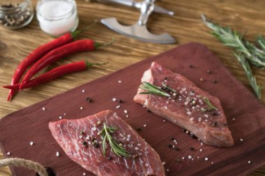 Taze çiğ biftek biberiye ve ahşap masa üzerine biber ile