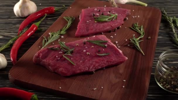 Sığır filetosu biber, biberiye ve sarımsak ile masa üzerinde. — Stok video