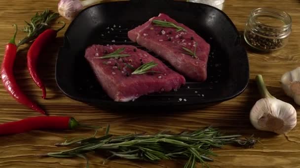 Filete de res en una sartén con pimienta, romero y ajo . — Vídeos de Stock