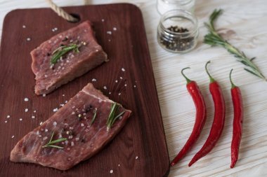 Taze çiğ biftek biberiye ve ahşap masa üzerine biber ile