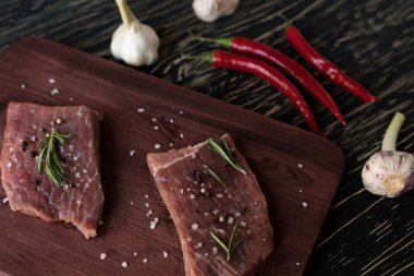 Biberiye, biber ve sarımsak ahşap masa ile taze çiğ biftek