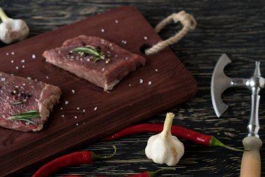 Biberiye, biber ve sarımsak ahşap masa ile taze çiğ biftek