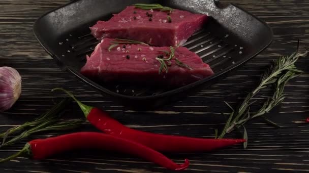 Filete de res en una sartén con pimienta, romero y ajo . — Vídeos de Stock