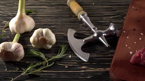 Beef fillet on a desk with pepper, rosemary axe and garlic. — Stock Video