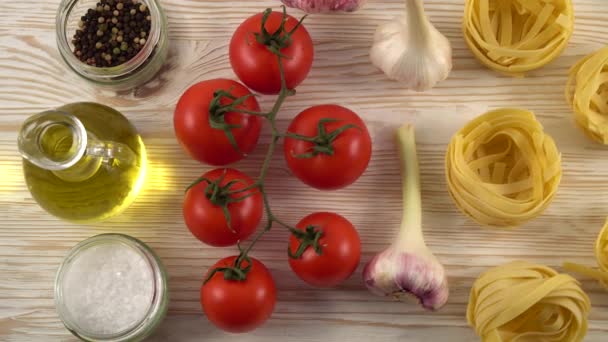 Macarrão, óleo, tomate e alho sobre fundo de madeira — Vídeo de Stock