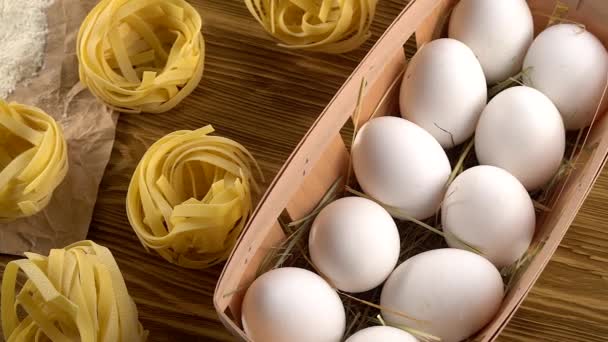 Макароны, яйца и мука на деревянном фоне — стоковое видео