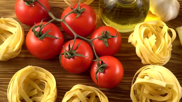 Makarna, petrol, domates ve sarımsak ahşap arka plan üzerinde — Stok video