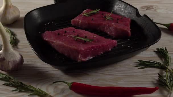 Filete de res en una sartén con pimienta, romero y ajo . — Vídeos de Stock