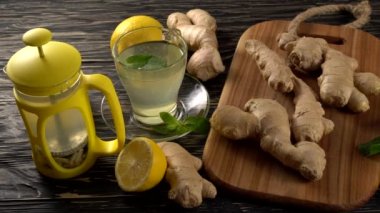 Zencefil çay limon, nane ve ballı ahşap arka plan üzerinde.