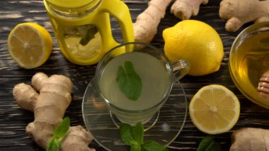 Zencefil çay limon, nane ve ballı ahşap arka plan üzerinde.