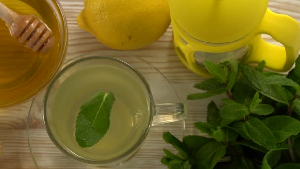 Ginger tea with lemon, mint and honey on wooden background. — Stock Video