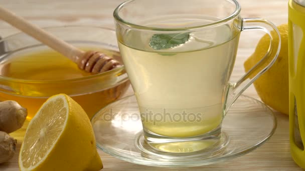 Имбирный чай с лимоном, мятой и медом на деревянном фоне . — стоковое видео