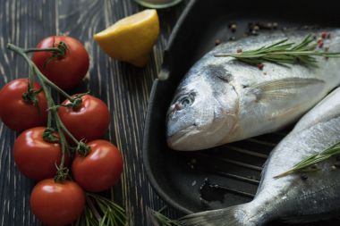 Çiğ balık pişirme ve malzemeler. Dorado, limon, otlar ve baharatlar.