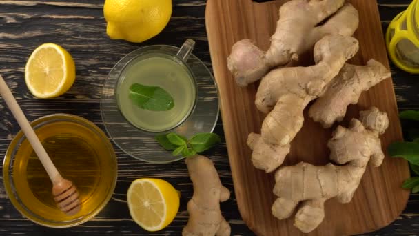 Ginger čaj s citronem, mátou a medem na dřevěné pozadí. — Stock video