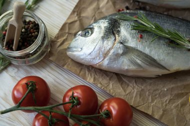 Çiğ balık pişirme ve malzemeler. Dorado, limon, otlar ve baharatlar.