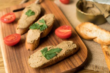 Ekmek arası ahşap tepsi üzerinde karaciğer pate.