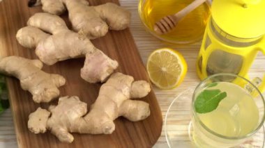 Zencefil çay limon, nane ve ballı ahşap arka plan üzerinde.
