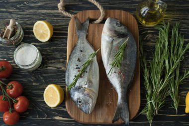 Çiğ balık pişirme ve malzemeler. Dorado, limon, otlar ve baharatlar.