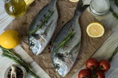 Çiğ balık pişirme ve malzemeler. Dorado, limon, otlar ve baharatlar.