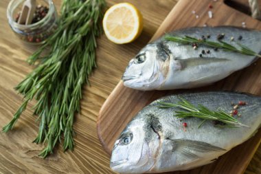 Çiğ balık pişirme ve malzemeler. Dorado, limon, otlar ve baharatlar.