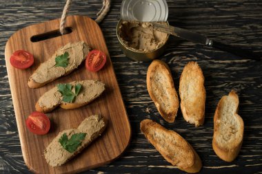 Ekmek arası ahşap tepsi üzerinde karaciğer pate.