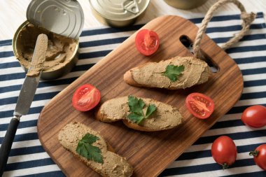 Ekmek arası ahşap tepsi üzerinde karaciğer pate.