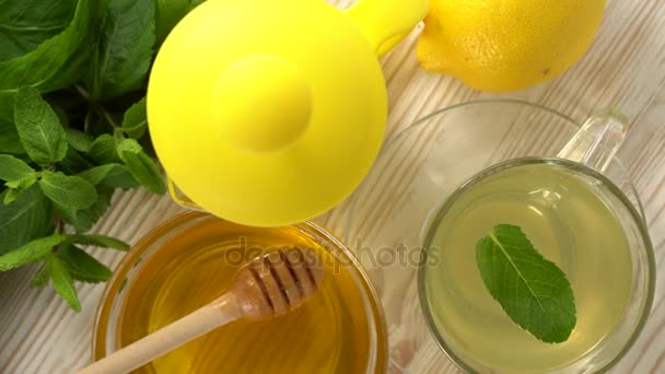 Té de jengibre con limón, menta y miel sobre fondo de madera . — Vídeo de stock