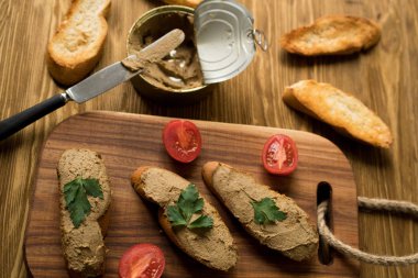 Ekmek arası ahşap tepsi üzerinde karaciğer pate.