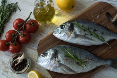 Çiğ balık pişirme ve malzemeler. Dorado, limon, otlar ve baharatlar.