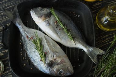 Çiğ balık pişirme ve malzemeler. Dorado, limon, otlar ve baharatlar.
