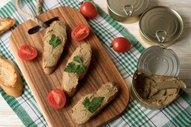 Ekmek arası ahşap tepsi üzerinde karaciğer pate.