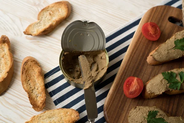 Ekmek arası ahşap tepsi üzerinde karaciğer pate.