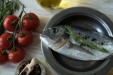 Çiğ balık pişirme ve malzemeler. Dorado, limon, otlar ve baharatlar.