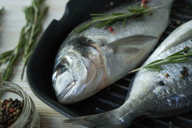 Çiğ balık pişirme ve malzemeler. Dorado, limon, otlar ve baharatlar.