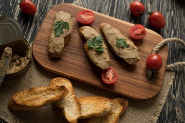 Ekmek arası ahşap tepsi üzerinde karaciğer pate.