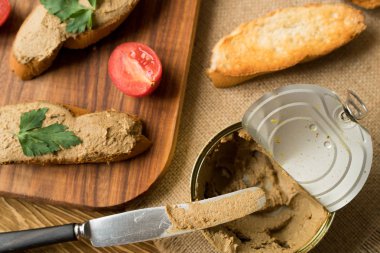 Ekmek arası ahşap tepsi üzerinde karaciğer pate.