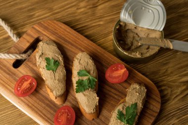 Ekmek arası ahşap tepsi üzerinde karaciğer pate.