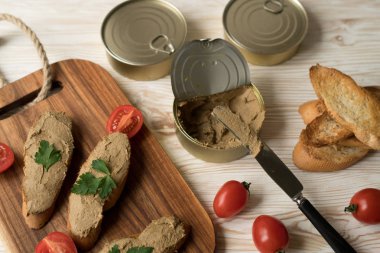 Ekmek arası ahşap tepsi üzerinde karaciğer pate.