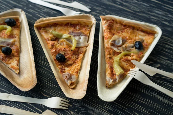 Una rebanada de pizza está en un plato de madera . Fotos De Stock Sin Royalties Gratis