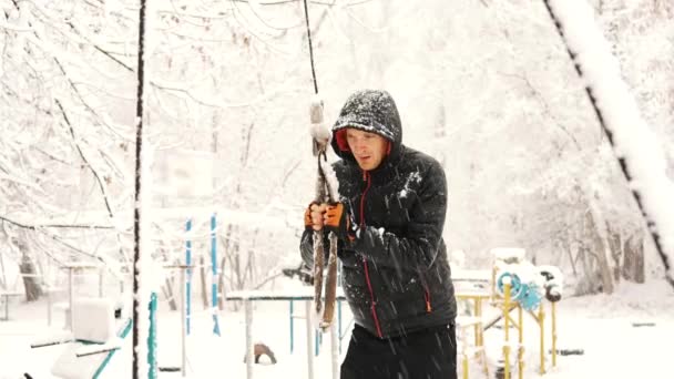 Young muscular man has the training and doing exercise outdoors in winter time. — Stock Video