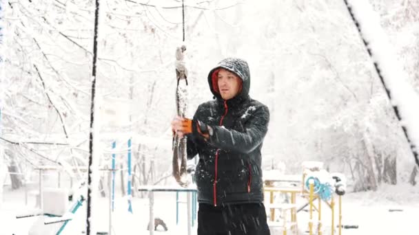 Молодий м'язистий чоловік тренується і займається вправами на відкритому повітрі в зимовий час . — стокове відео