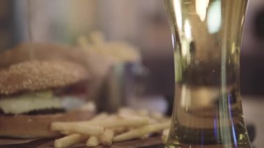 Hamburger bira ve masanın üzerine patates kızartması ile.